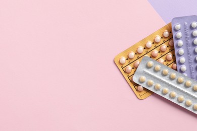 Photo of Blisters of contraceptive pills on color background, top view. Space for text