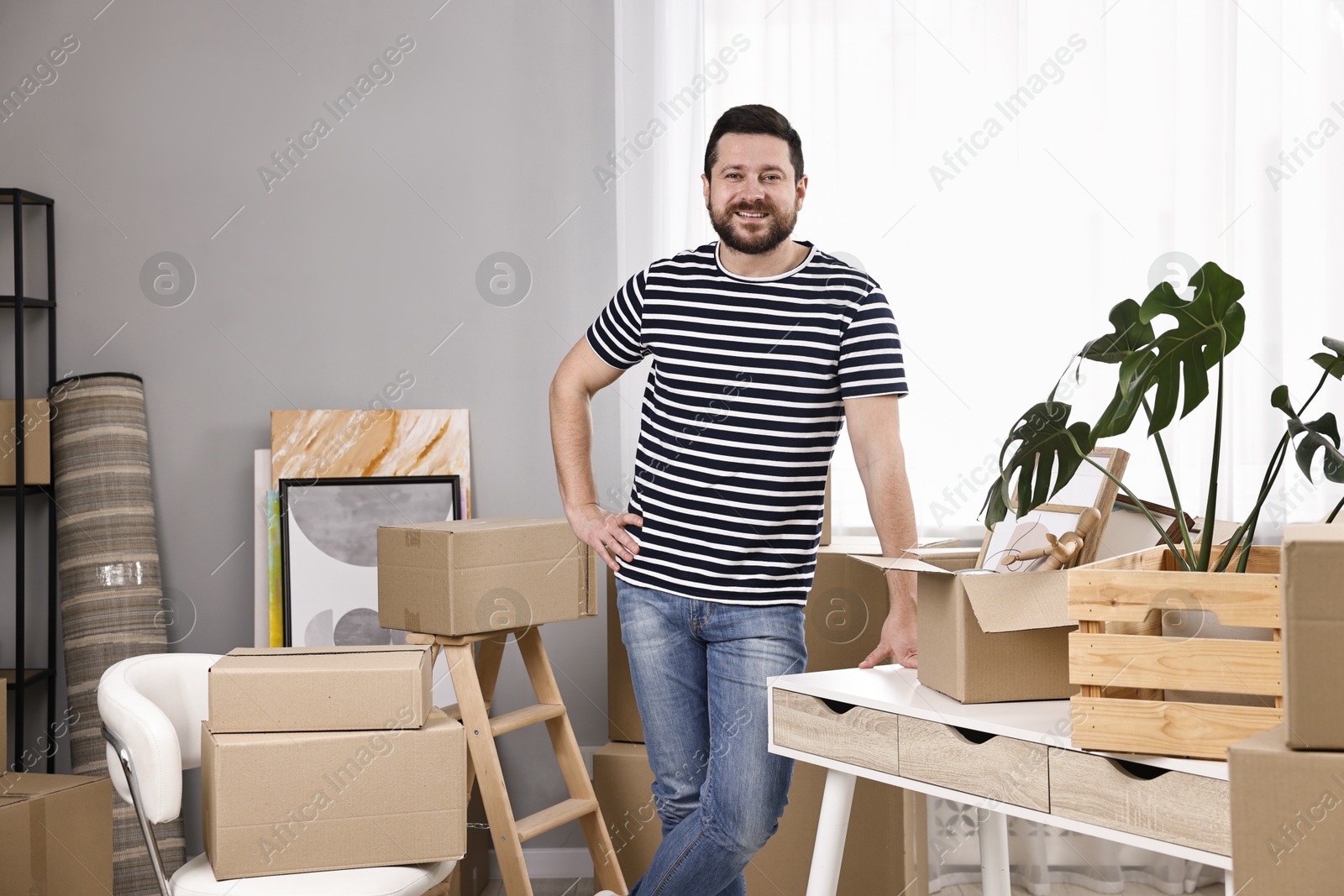 Photo of Moving day. Man with his belongings in new home