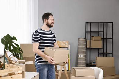 Moving day. Man with cardboard box in his new home