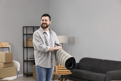 Moving day. Man with rug in his new home