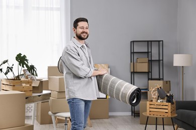 Moving day. Man with rug in his new home