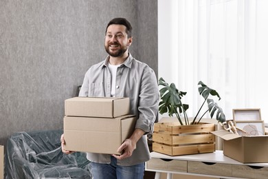 Moving day. Man with cardboard boxes in his new home