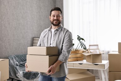 Moving day. Man with cardboard boxes in his new home