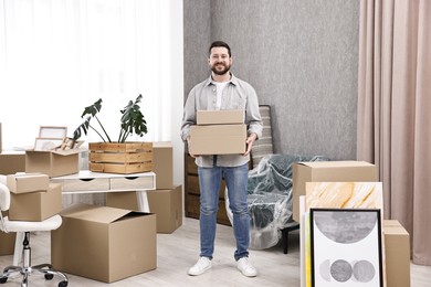 Photo of Moving day. Man with cardboard boxes in his new home