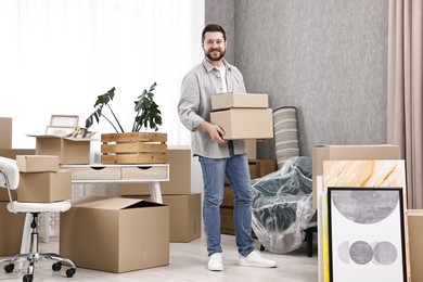 Moving day. Man with cardboard boxes in his new home