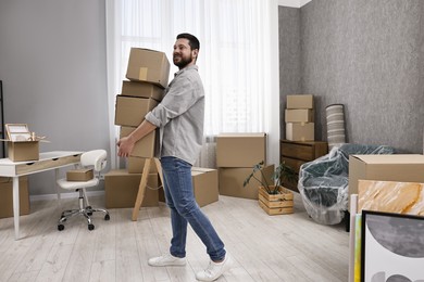 Moving day. Man with cardboard boxes in his new home