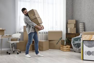 Photo of Moving day. Man with cardboard boxes in his new home