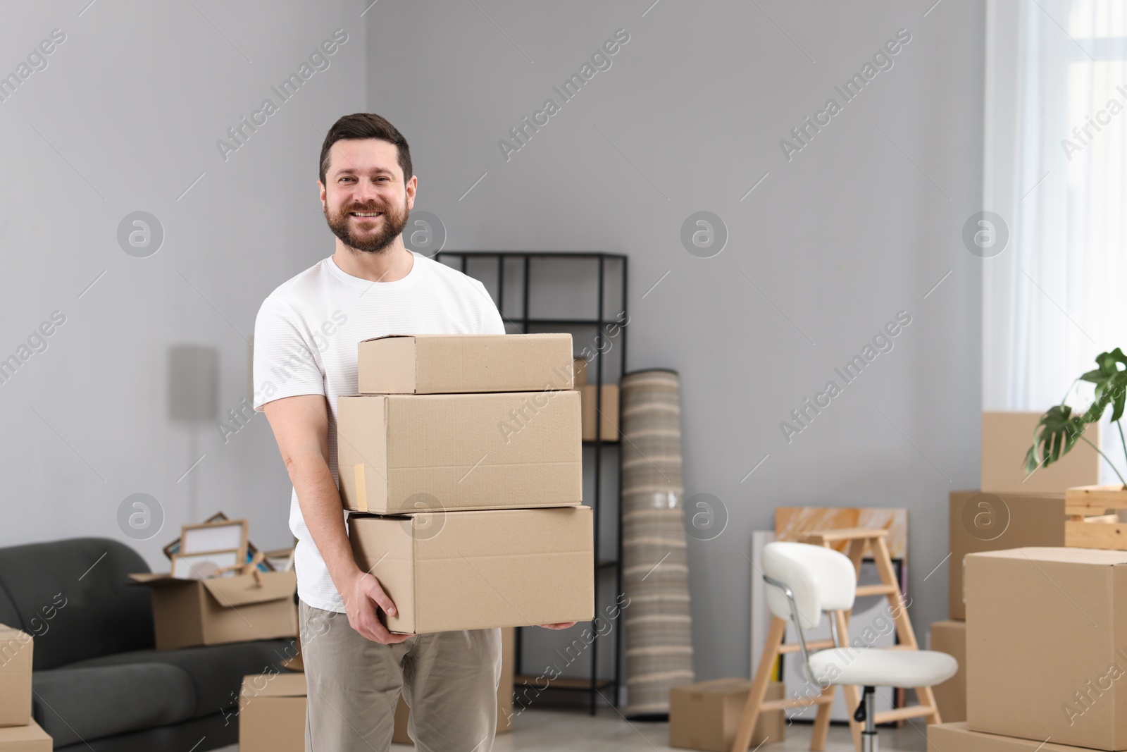 Photo of Moving day. Man with cardboard boxes in his new home