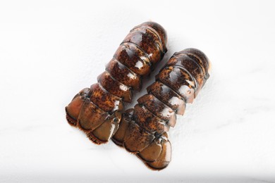 Photo of Raw lobster tails on white table, flat lay