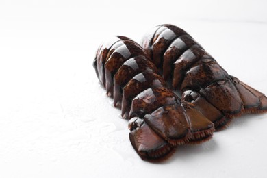 Raw lobster tails on white table, closeup. Space for text