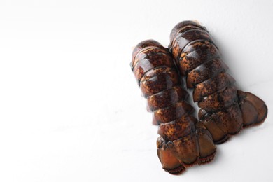 Photo of Raw lobster tails on white table, flat lay. Space for text