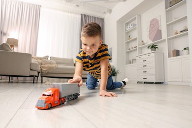 Little boy playing with toy car at home, low angle view