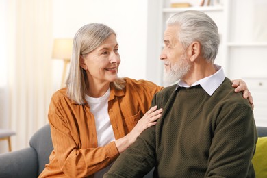 Photo of Happy elderly couple on sofa at home