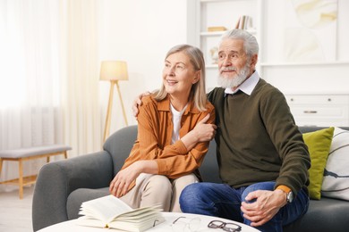 Happy elderly couple on sofa at home