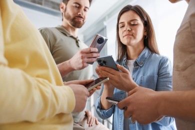 Internet addiction. Group of people with smartphones indoors, closeup