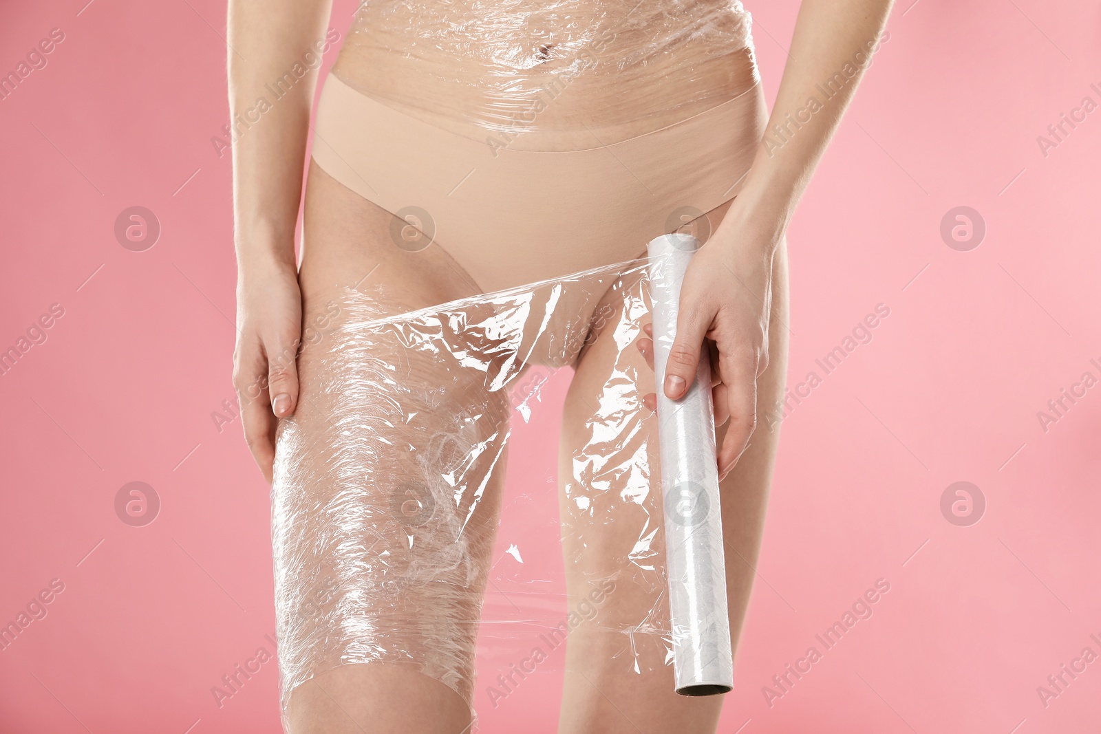 Photo of Woman doing spa body wraps on pink background, closeup