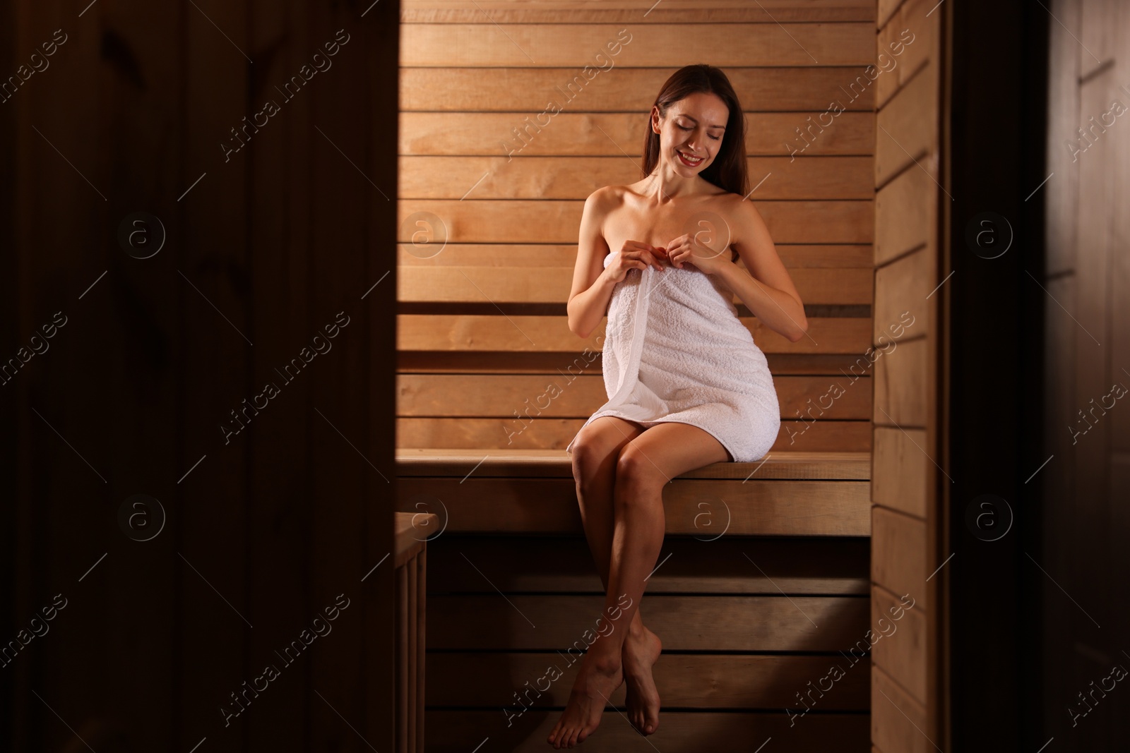 Photo of Smiling woman sitting on bench at sauna. Space for text