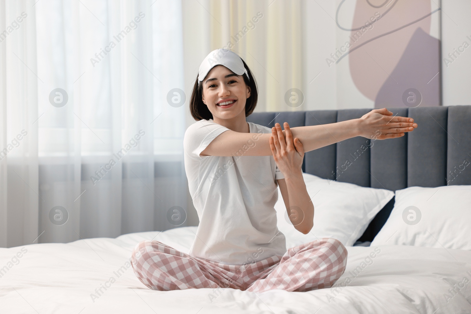 Photo of Young woman exercising on bed at home. Morning routine