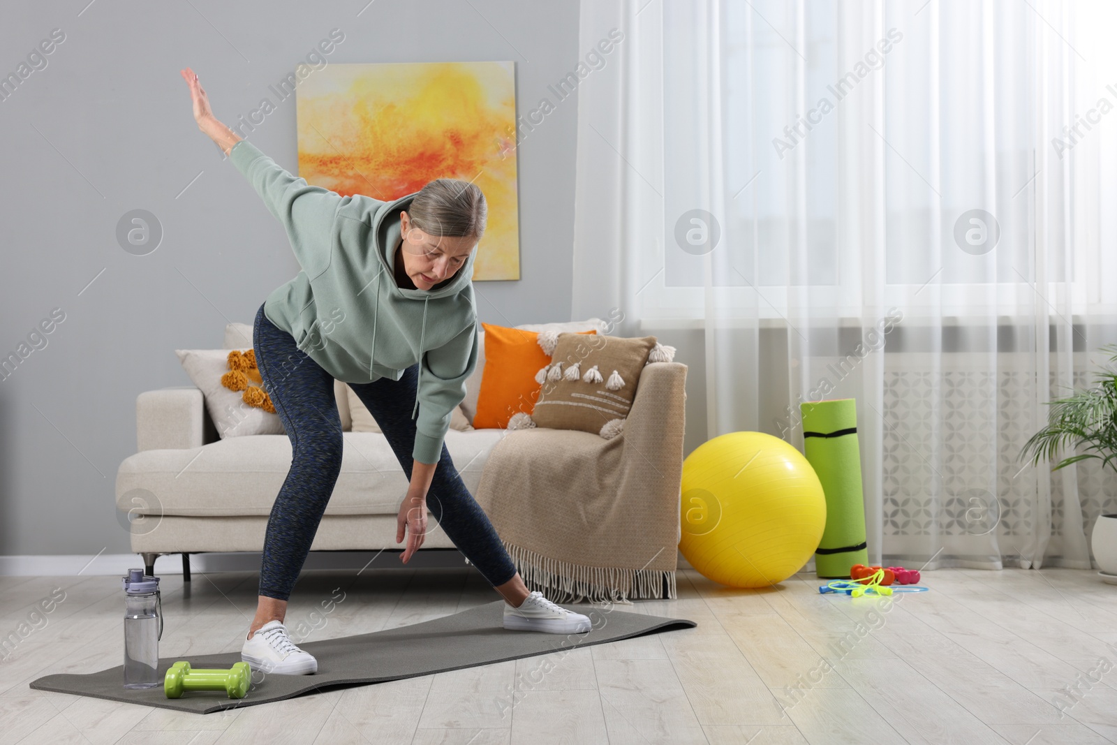 Photo of Elderly woman doing exercise at home. Healthy leisure