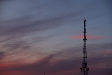 Transmission tower against beautiful sky at sunset