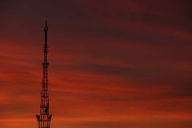 Transmission tower against beautiful sky at sunset