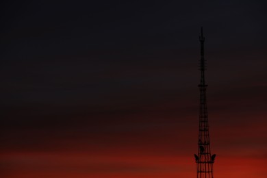 Transmission tower against beautiful sky at sunset