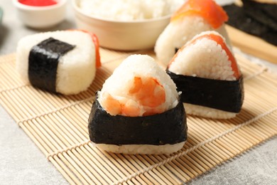 Photo of Tasty onigiri (Japanese rice balls) served on light table, closeup