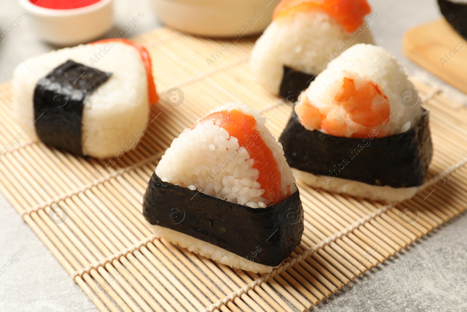Tasty onigiri (Japanese rice balls) served on light table, closeup Photo of Tasty onigiri (Japanese rice balls) served on light table, closeup