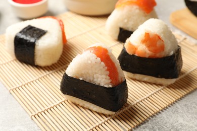 Photo of Tasty onigiri (Japanese rice balls) served on light table, closeup