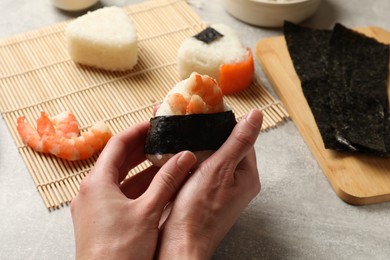 Photo of Woman making onigiri (Japanese rice balls) at light table, closeup