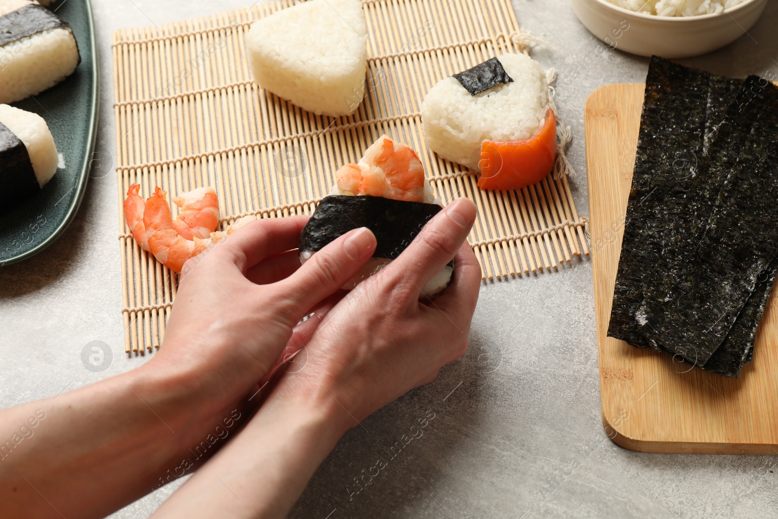 Woman making onigiri (Japanese rice balls) at light table, closeup Photo of Woman making onigiri (Japanese rice balls) at light table, closeup