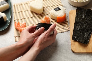 Photo of Woman making onigiri (Japanese rice balls) at light table, closeup