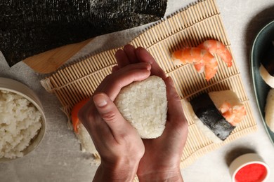 Photo of Woman making onigiri (Japanese rice balls) at light table, top view