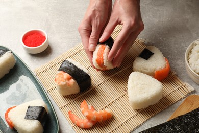 Photo of Woman making onigiri (Japanese rice balls) at light table, closeup