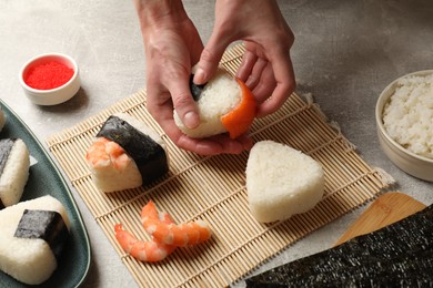 Photo of Woman making onigiri (Japanese rice balls) at light table, closeup