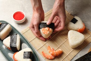 Photo of Woman making onigiri (Japanese rice balls) at light table, closeup