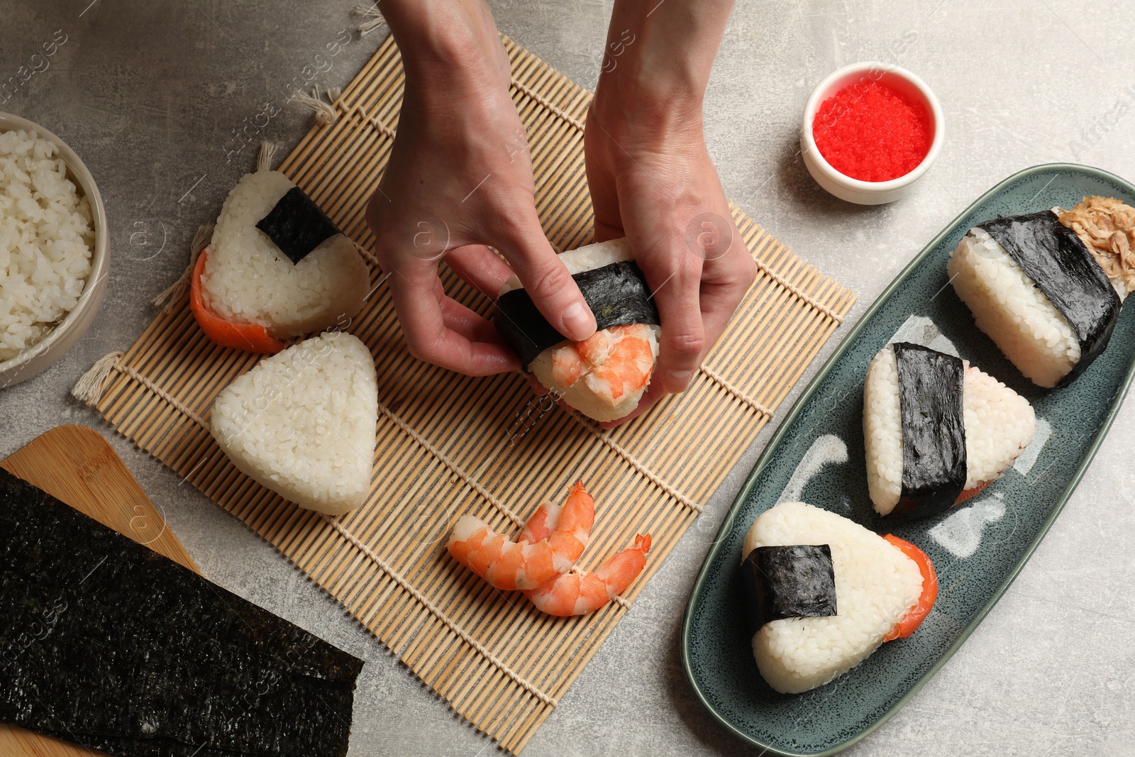 Woman making onigiri (Japanese rice balls) at light table, closeup Photo of Woman making onigiri (Japanese rice balls) at light table, closeup