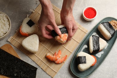 Photo of Woman making onigiri (Japanese rice balls) at light table, closeup