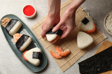 Photo of Woman making onigiri (Japanese rice balls) at light table, closeup