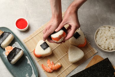 Photo of Woman making onigiri (Japanese rice balls) at light table, closeup