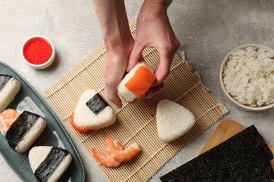 Photo of Woman making onigiri (Japanese rice balls) at light table, top view
