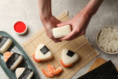 Photo of Woman making onigiri (Japanese rice balls) at light table, top view