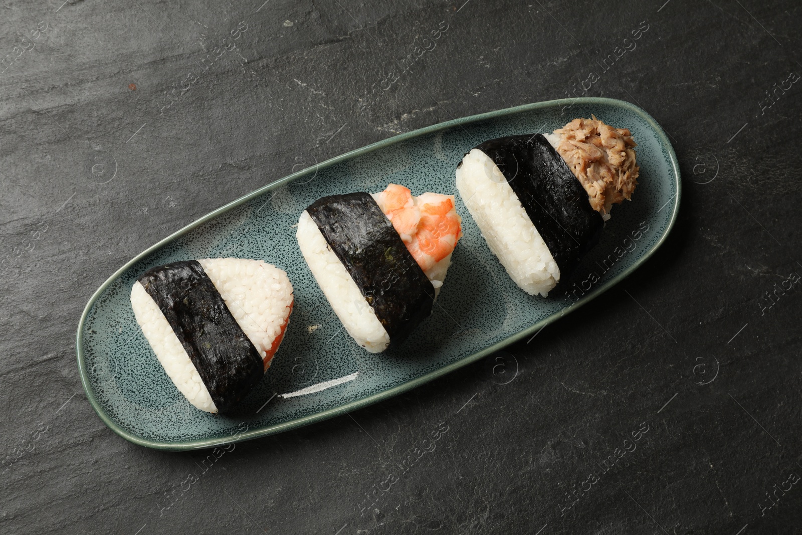 Tasty onigiri (Japanese rice balls) served on black table, top view Photo of Tasty onigiri (Japanese rice balls) served on black table, top view