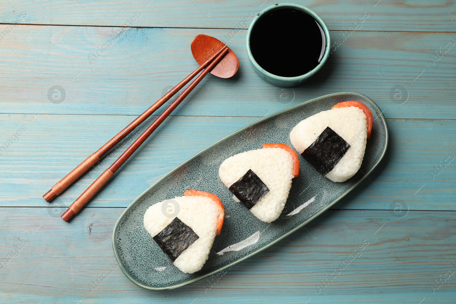 Tasty onigiri (Japanese rice balls) served on blue wooden table, flat lay Photo of Tasty onigiri (Japanese rice balls) served on blue wooden table, flat lay