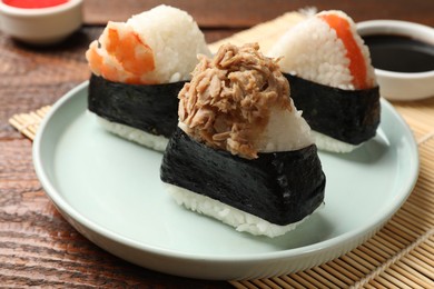 Photo of Tasty onigiri (Japanese rice balls) served on wooden table, closeup