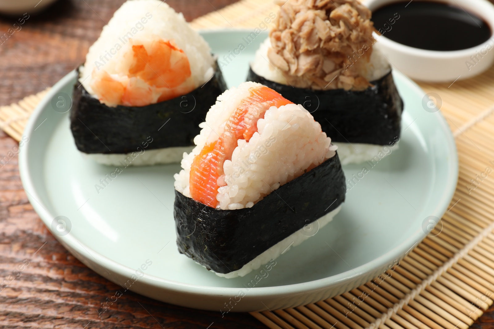 Tasty onigiri (Japanese rice balls) served on wooden table, closeup Photo of Tasty onigiri (Japanese rice balls) served on wooden table, closeup