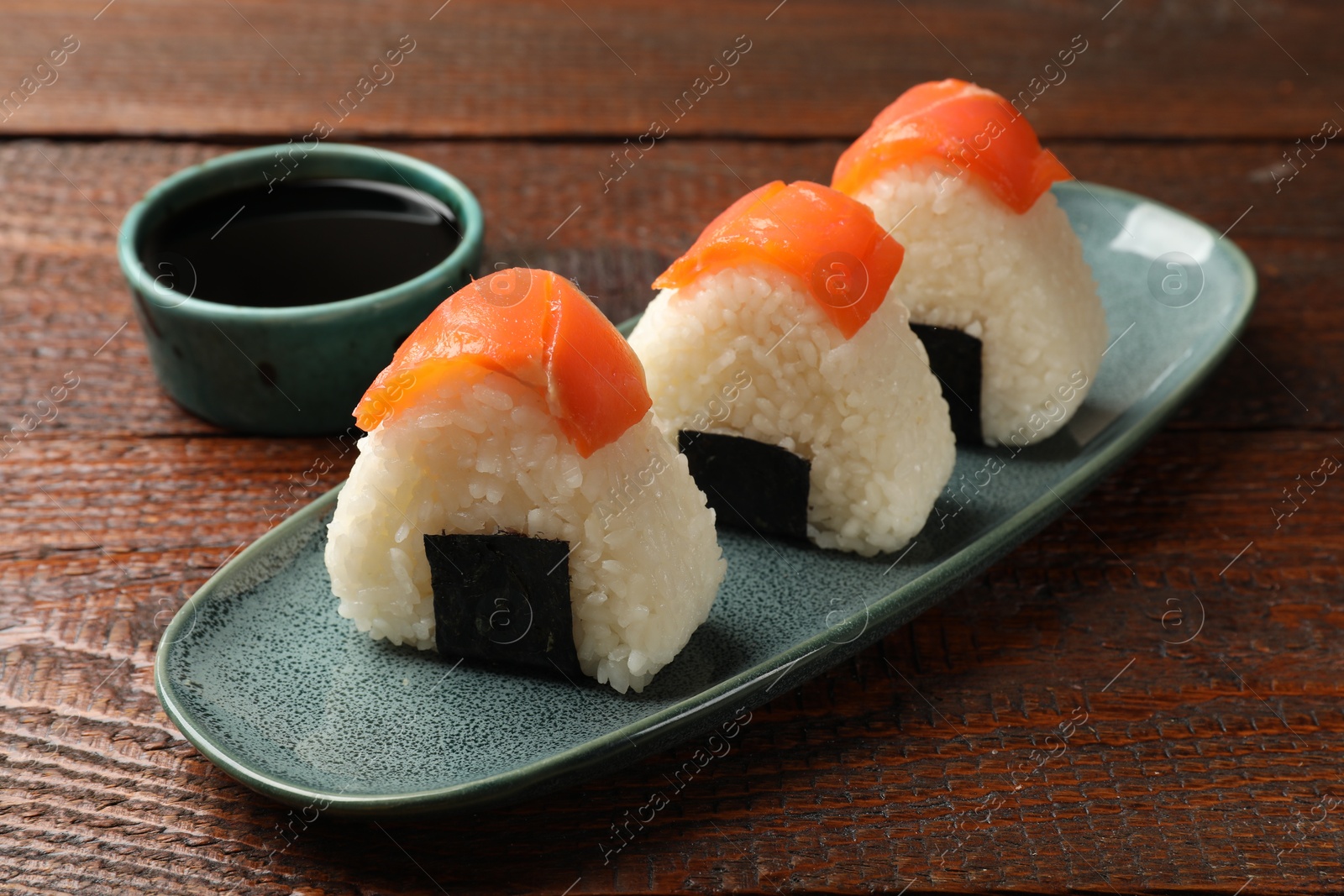Tasty onigiri (Japanese rice balls) served on wooden table, closeup Photo of Tasty onigiri (Japanese rice balls) served on wooden table, closeup