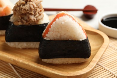 Photo of Tasty onigiri (Japanese rice balls) served on white table, closeup
