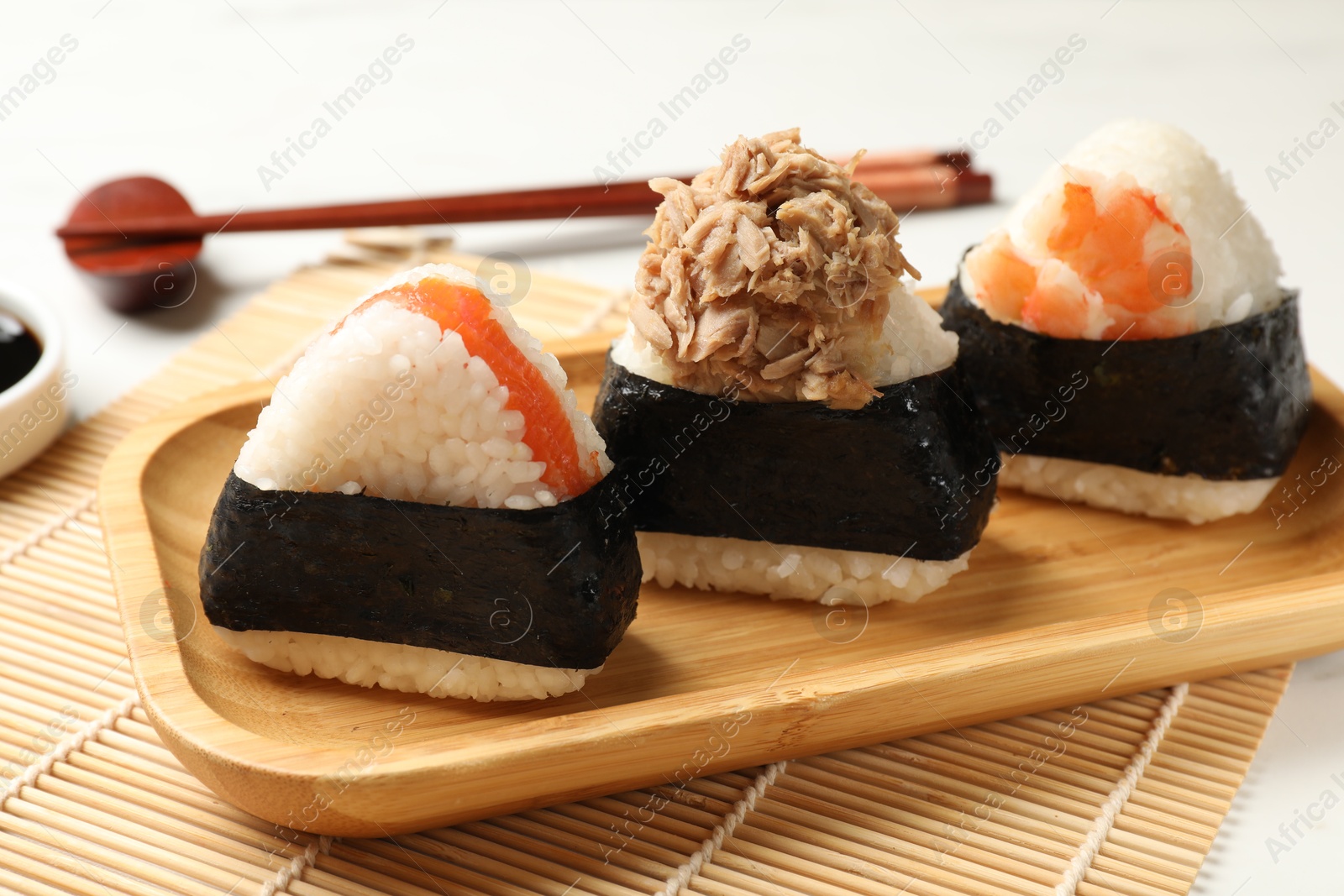 Tasty onigiri (Japanese rice balls) served on white table, closeup Photo of Tasty onigiri (Japanese rice balls) served on white table, closeup