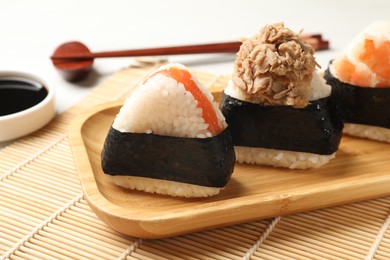 Photo of Tasty onigiri (Japanese rice balls) served on white table, closeup